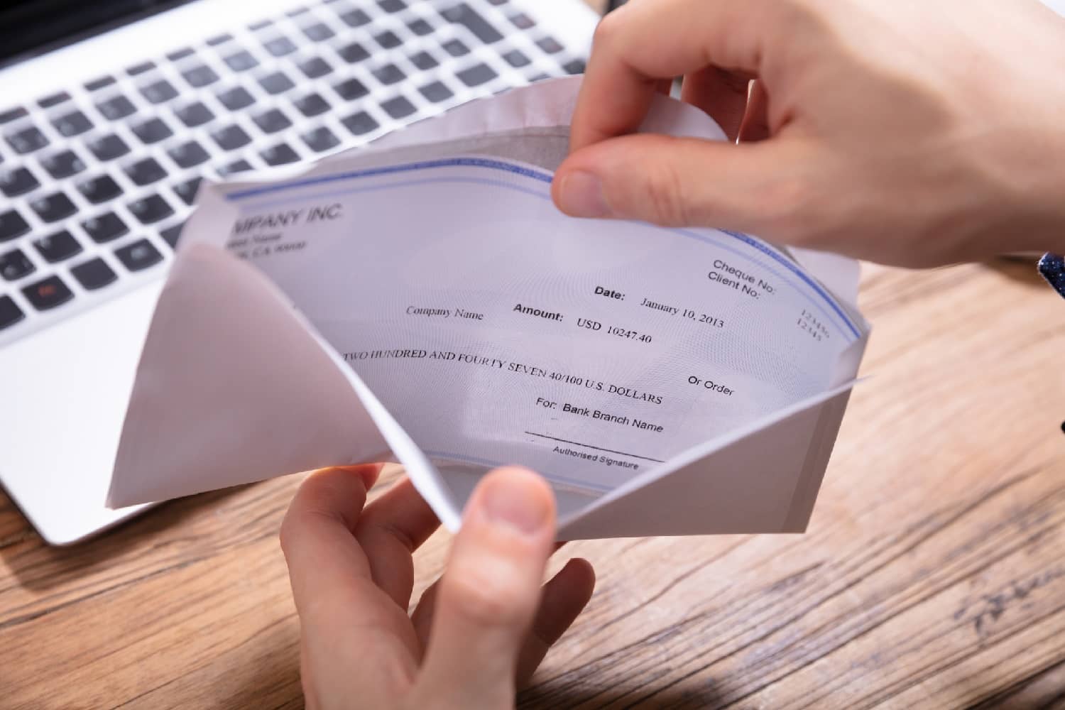 hand removing a paycheck from an envelope