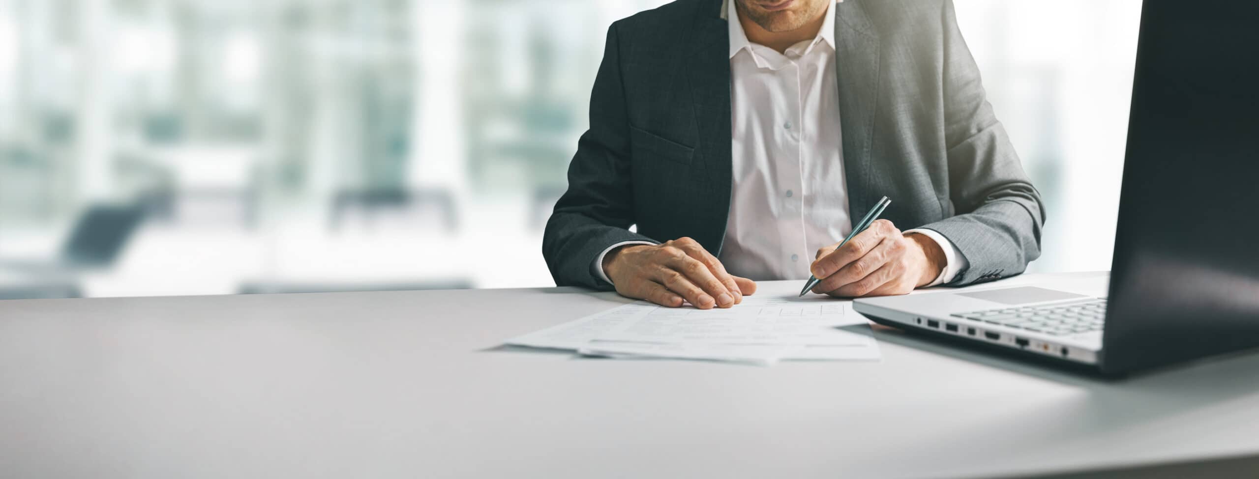 Man in a suit writing on paper
