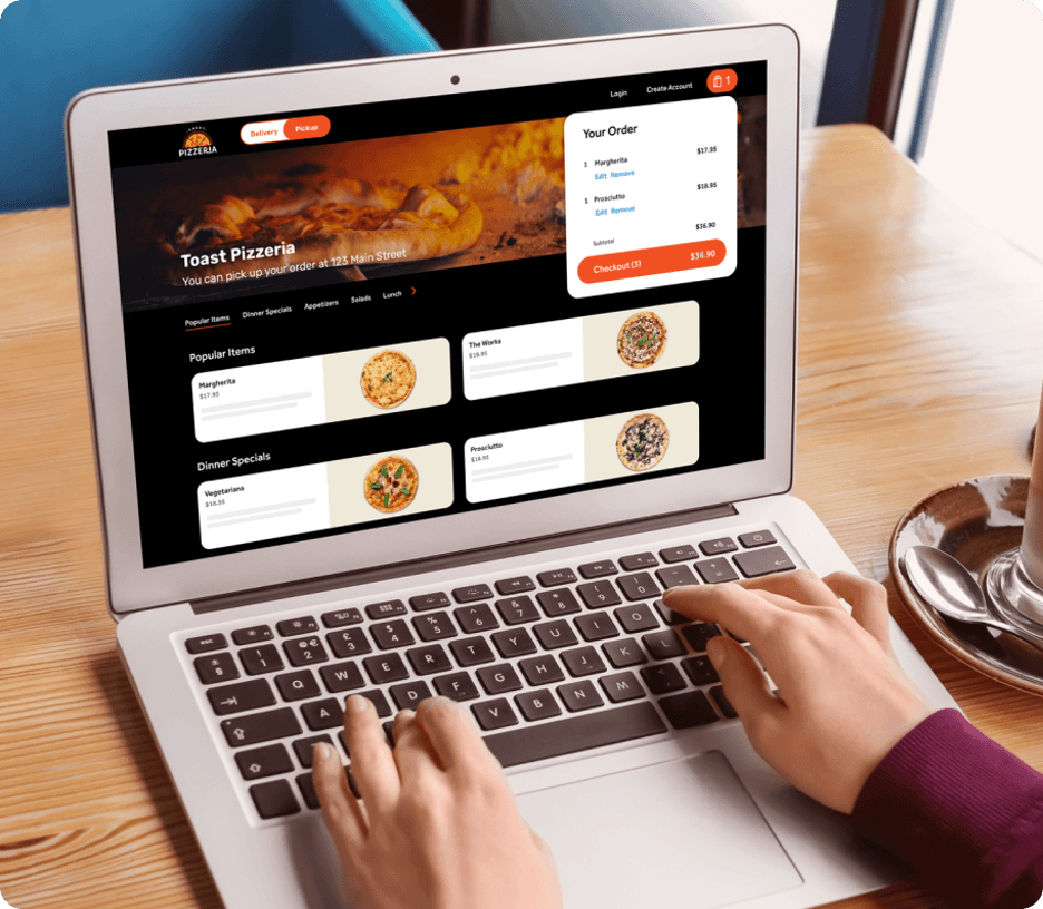 Person using a laptop using the Toast platform to make an order