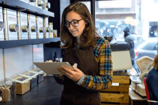 Woman in a shop using a handheld POS system
