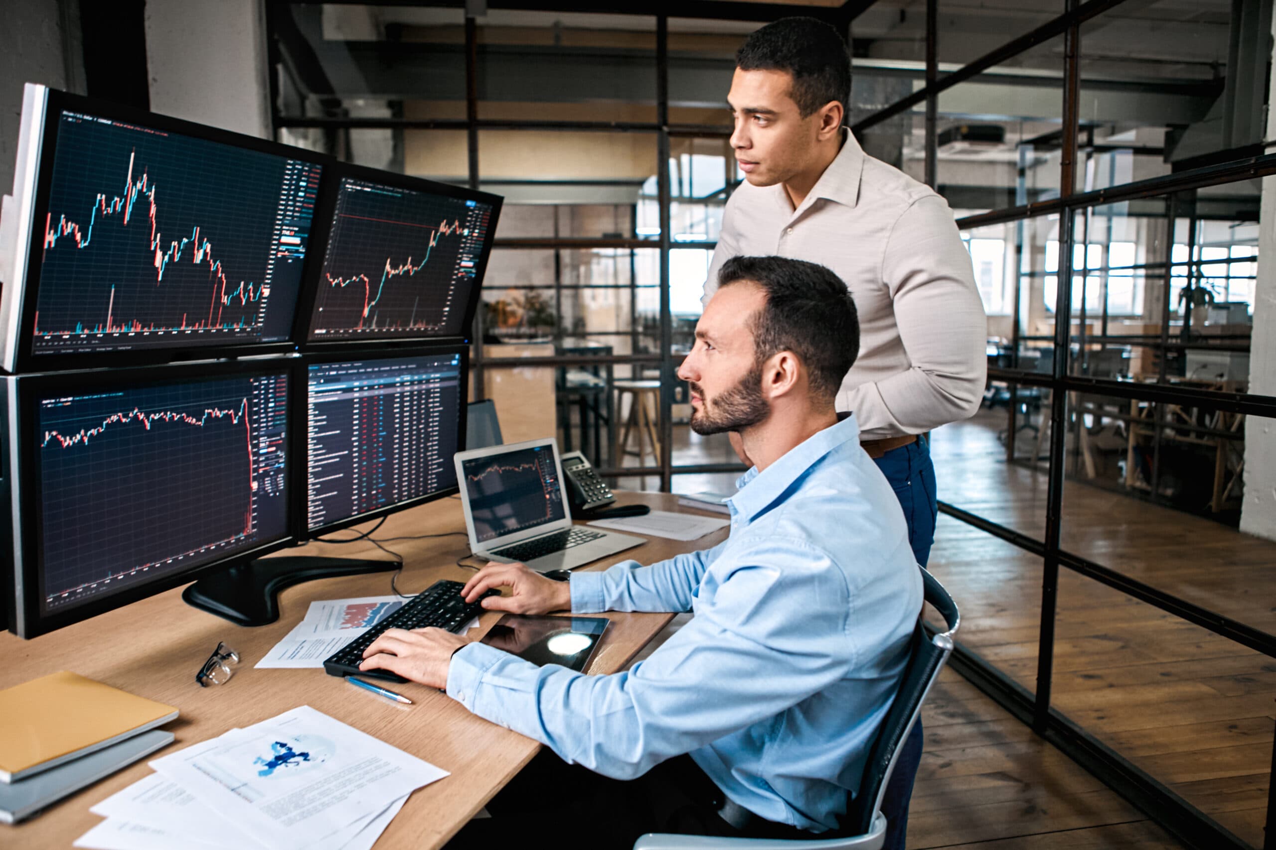 Two traders checking a compuer