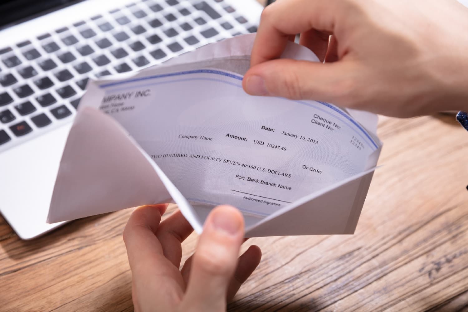 hand removing a paycheck from an envelope