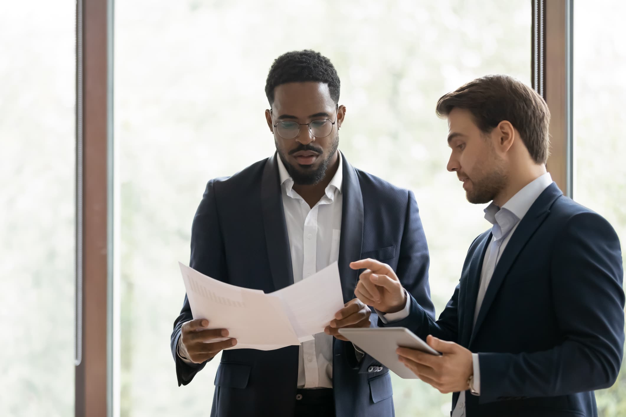 two colleagues discussing while looking at papers