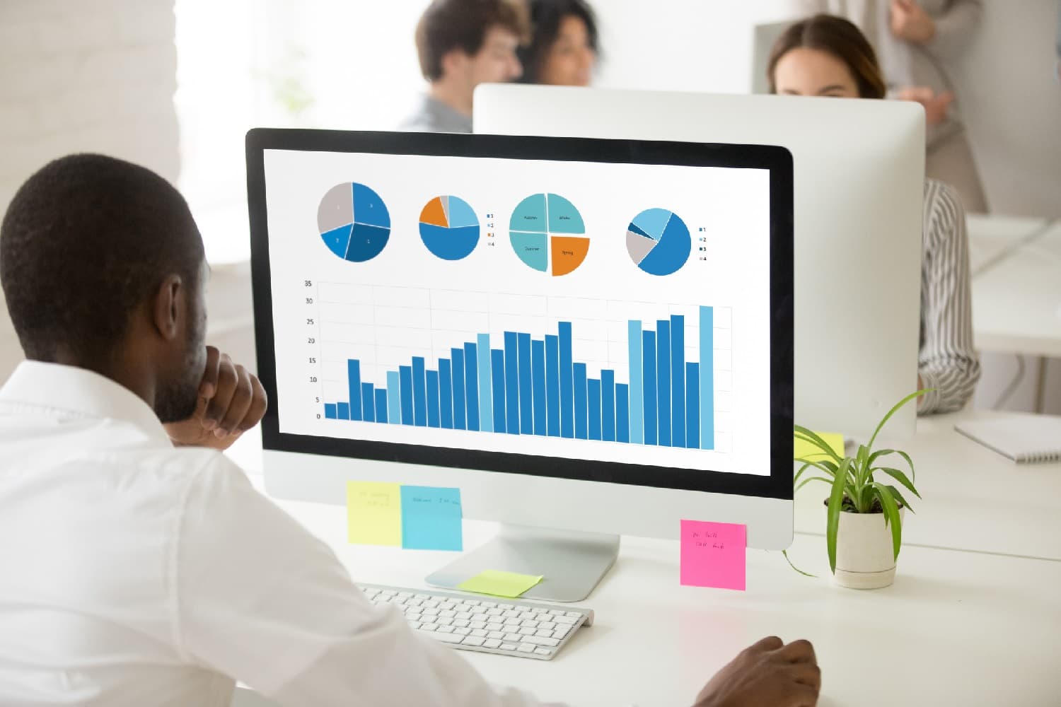 businessman looking at a computer screen with data and graphs