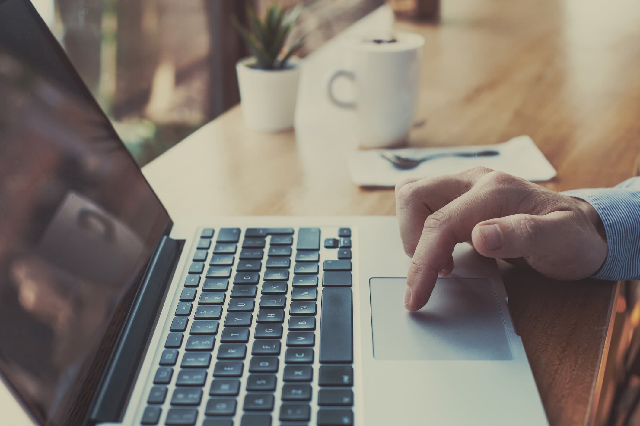 hand using a trackpad on a laptop