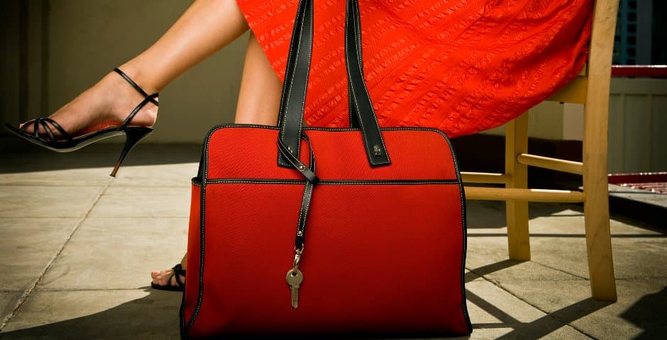 woman in a red dress sitting next to a red purse
