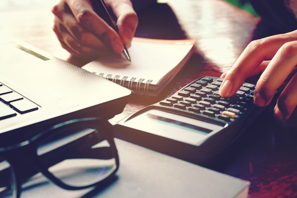 hand using a calculator and notebook