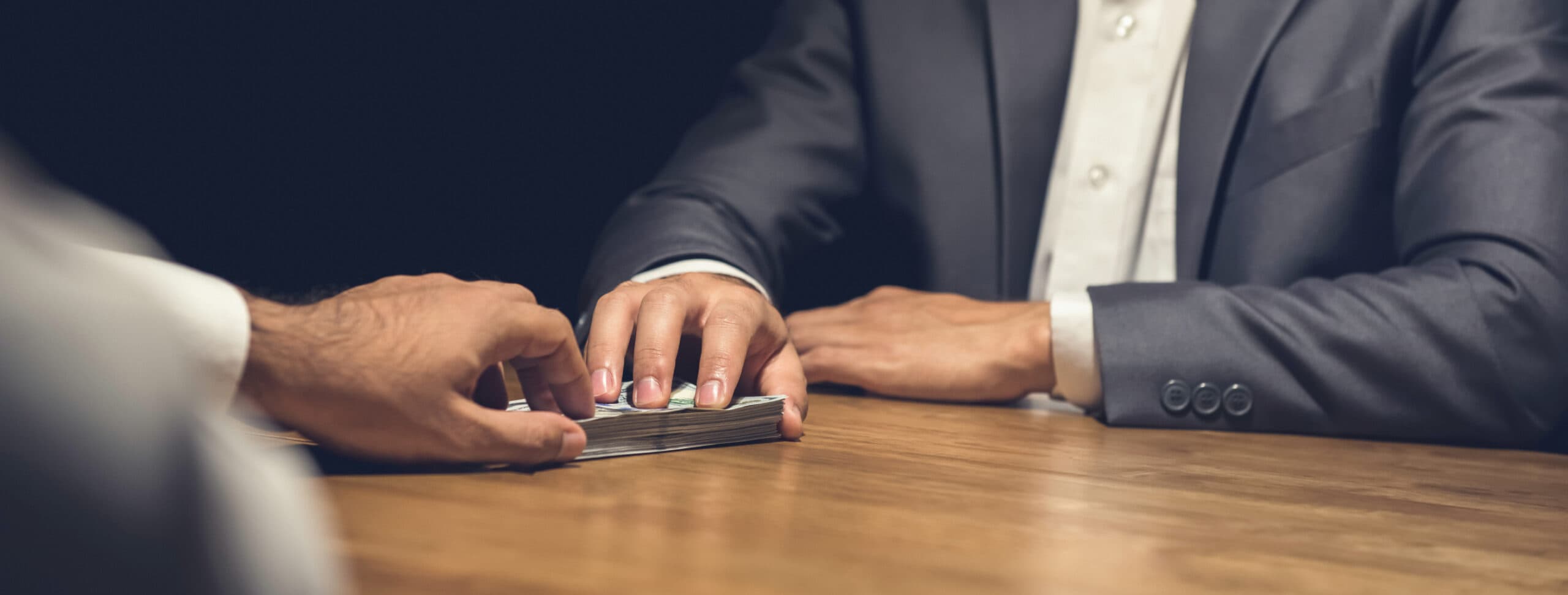 person handing someone a pile of cash