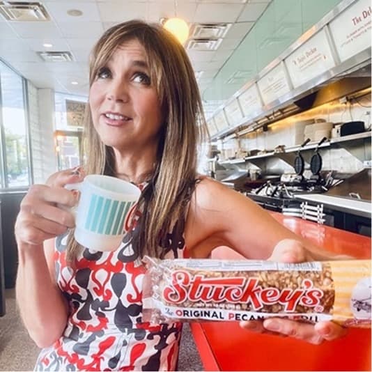 Woman holding a Stuckey's bar in a diner