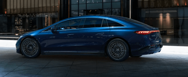 Mercedes EQS sedan parked outside a modern office building at night