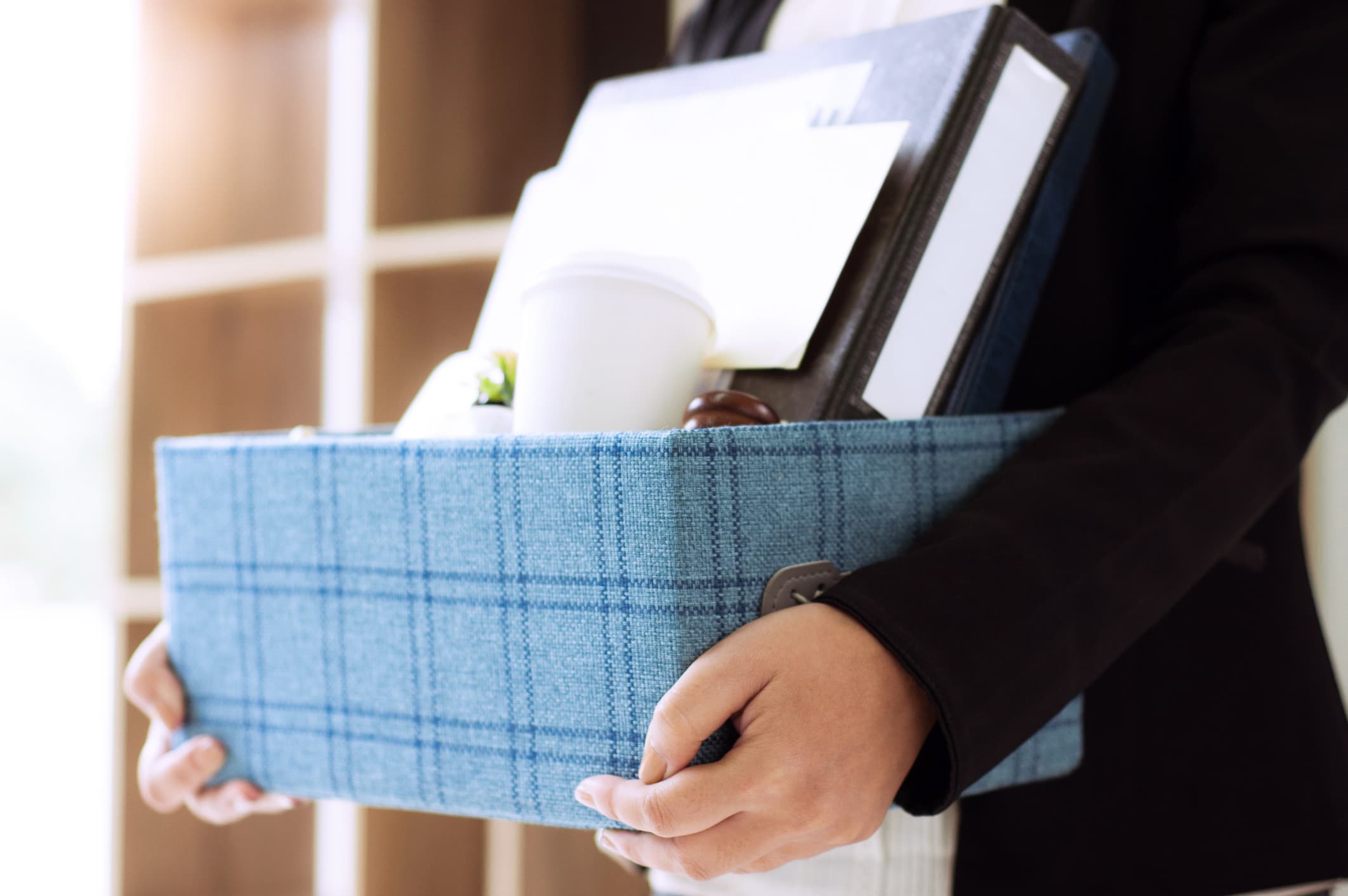 person carrying packed office belongings