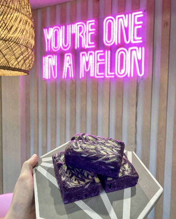 Neon sign with brownies in front of it